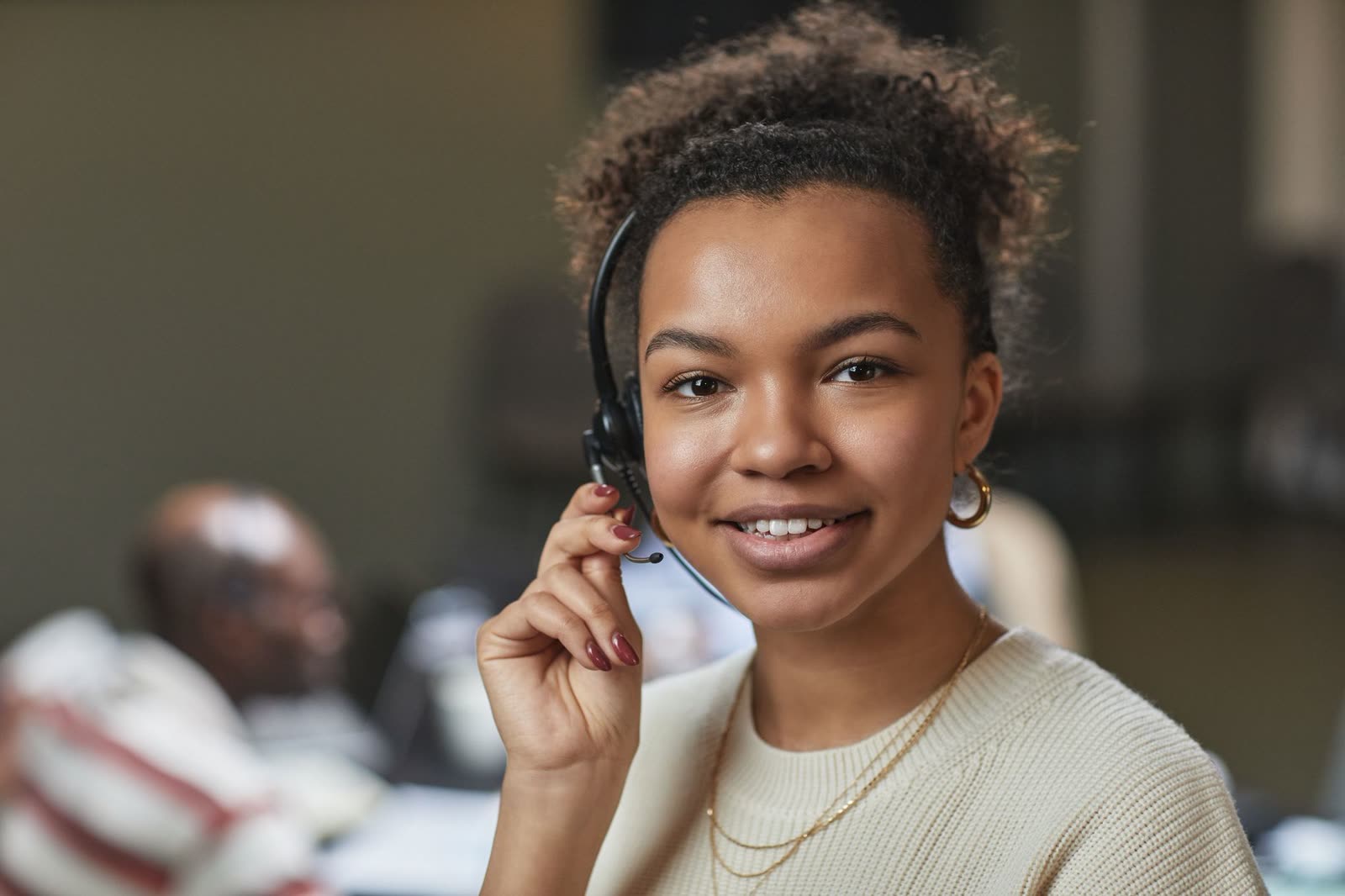 A smiling customer service agent wearing a headset