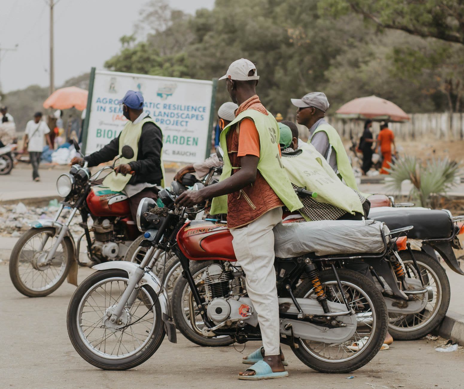 Motorbike riders in reflective vests waiting at a stand